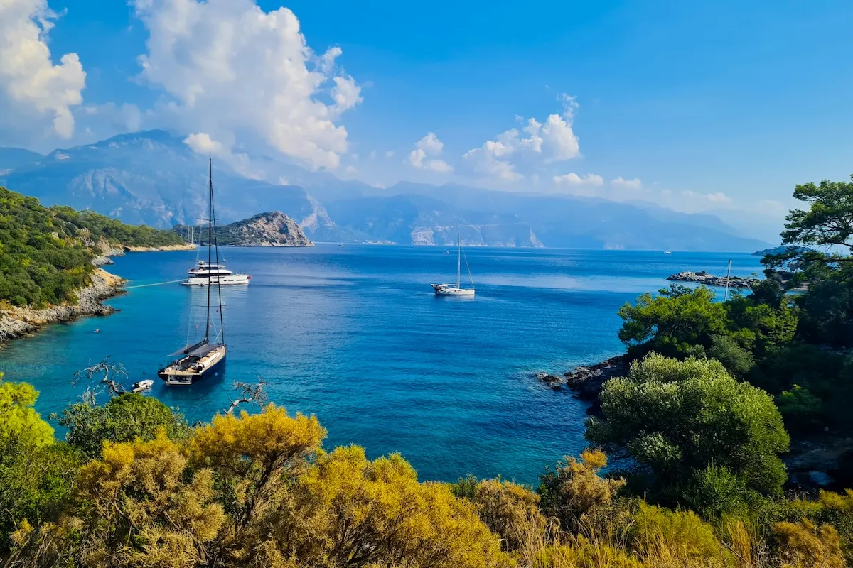 Fethiye, Akdeniz tatil yerleri arasında turkuaz koyları, demirli yelkenlileri, yemyeşil kıyıları ve dağ manzarasıyla öne çıkıyor.