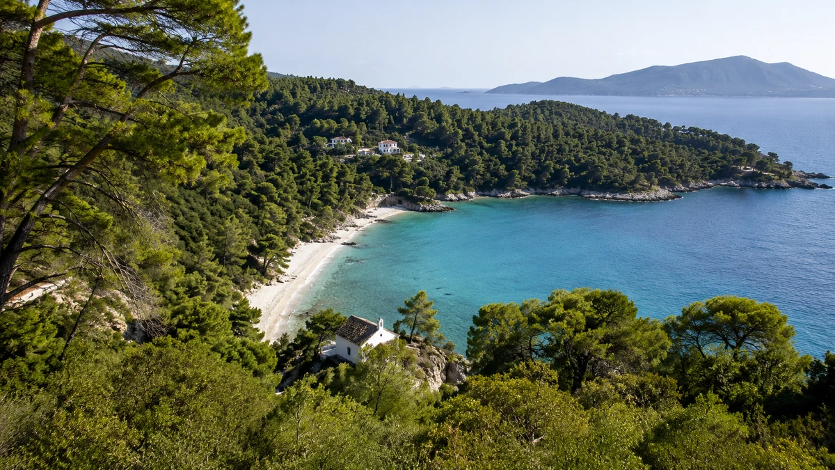 Skopelos Adası'nın yemyeşil doğasıyla çevrili bu huzurlu koyda, berrak turkuaz denizi beyaz çakıllı plajla buluşurken, kıyıda duran küçük beyaz bir şapel bu yeşil koyun pitoresk manzarasını tamamlıyor.