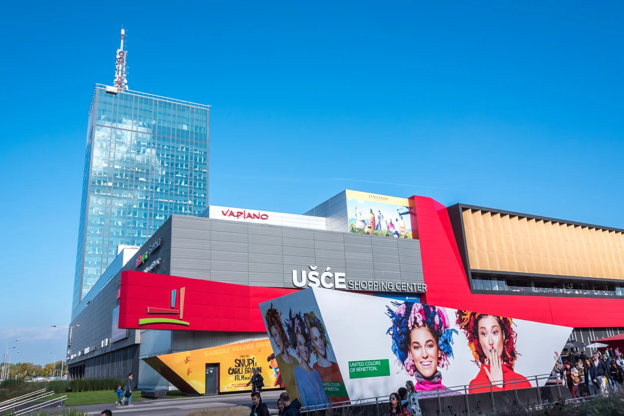 USCE Alışveriş Merkezi'nin ışık alan, ferah iç mekanında, birçok katı birbirine bağlayan uzun yürüyen merdivenler ve modern mimariye sahip galeriler dikkat çekiyor; ziyaretçilerin keyifli bir alışveriş deneyimi yaşadığı, çeşitli markaların mağazalarının ve şık dekorasyonun göz alıcı olduğu geniş bir alan açıkça görülüyor.