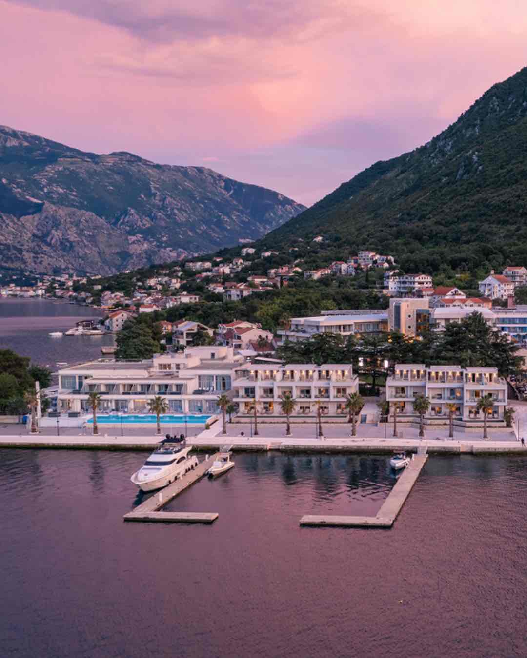 Günbatımının pembe tonlarına bürünen Kotor Körfezi kıyısında konumlanan Hyatt Regency Kotor Bay Resort, modern mimarisi, iskelesindeki lüks yatları ve Adriyatik'in heybetli dağlarla buluştuğu eşsiz Karadağ manzarasını sergiliyor.