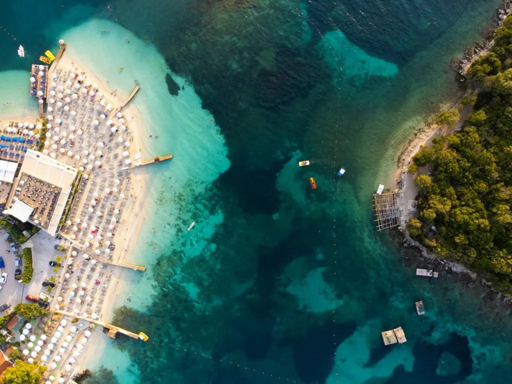 Arnavutluk Ksamil Plajı’nın havadan görünümü; turkuaz deniz, beyaz kumlar ve yemyeşil koy – vizesiz tatil destinasyonları