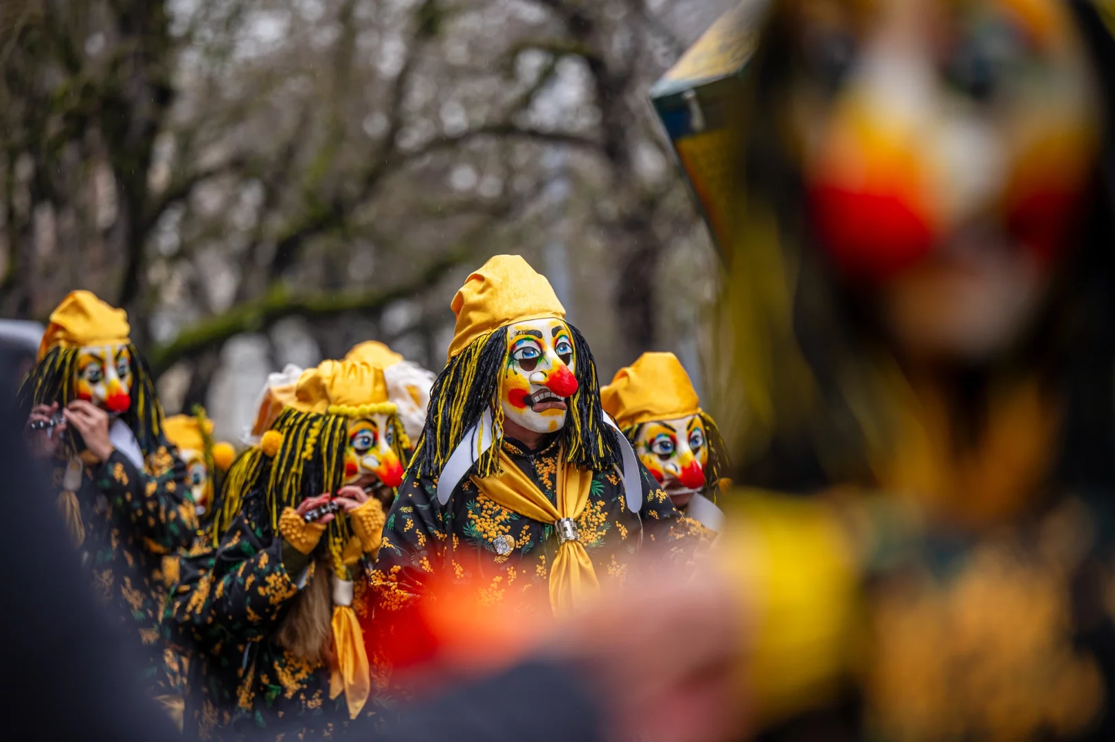 Basel gezilecek yerler arasında Fasnacht Karnavalı geçit töreninde maskeli ve renkli kostümlü katılımcıların flüt çaldığı sahne.