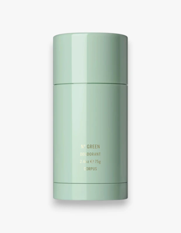 Açık gri bir arka plan üzerinde dikey konumlandırılmış, pürüzsüz ve parlak yüzeyli, pastel mint yeşili renkte bir silindirik deodorant stick ürünü, üzerinde N° GREEN DEODORANT 2.6 oz e 75g CORPUS yazılı olup, doğal içeriklere sahip modern bir kişisel bakım ürününü temsil etmektedir.