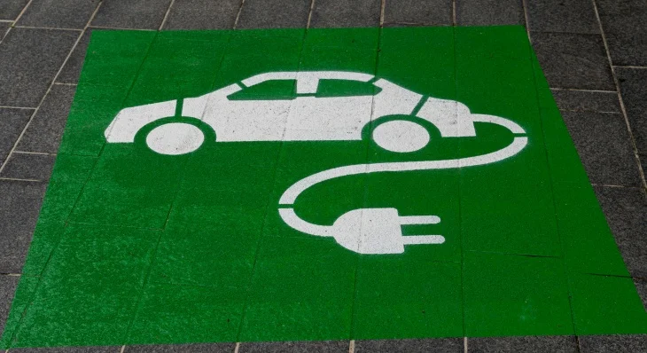 Yeşil zemin üzerine beyaz renkte çizilmiş, bir elektrikli otomobili ve şarj kablosunu gösteren sembol, çevreci taşıma çözümlerinin ve elektrikli otomobillerin menzil kavramının temelini oluşturan şarj istasyonlarının önemini vurguluyor.