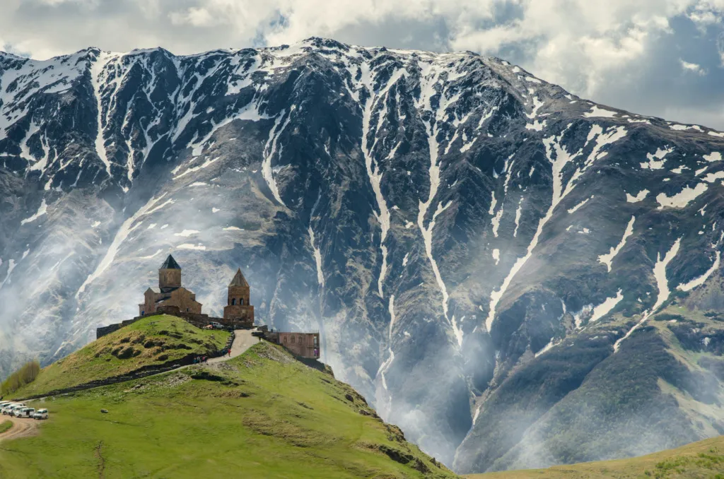 Gürcistan Kazbegi’de Gergeti Trinity Kilisesi ve karlı Kafkas Dağları manzarası – kimlikle vizesiz seyahat rotası