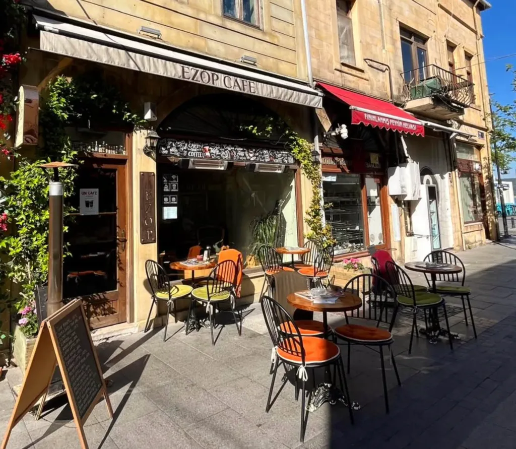 Heybeliada’daki Ezop Cafe’nin dış cephesi, sokak üzerine yerleştirilmiş renkli sandalyeler ve yuvarlak masalar