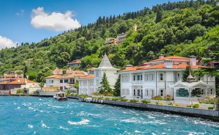 İstanbul Boğazı kıyısında yer alan beyaz ahşap yalılar ve yemyeşil yamaçlar, yaz güneşinde parlayan mavi denizle birleşiyor.
