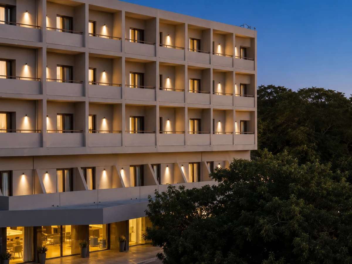 Alacakaranlıkta, birçok odasının ve balkonunun ışıkları yanan modern Kriti Hotel binası, lobisinin sıcak aydınlatması ve yemyeşil ağaçlarla çevrili duruşuyla Girit otelleri arasında dikkat çekiyor, misafirlerine huzurlu bir konaklama vadediyor.