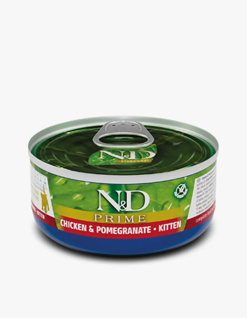 Beyaz bir arka plan üzerinde hafif açılı konumlanmış, N&D Prime markalı, Chicken & Pomegranate ve Kitten ibareleri belirgin, parlak yeşil etiketinde sulu mama görüntüsü olan, yavru kediler için özel formüle edilmiş tavuklu ve narlı yaş kedi maması konserve kutusu dikkat çekiyor.