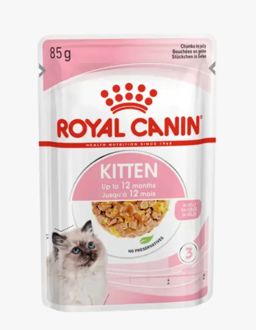 Beyaz ve pembe tonlarındaki Royal Canin yavru kedi yaş maması paketinde, mavi gözlü bir yavru kedi fotoğrafı, jöleli ve parçacıklı mama görüntüsü, 85 gram ağırlığı ile 12 aya kadar kediler için uygun olduğu ve koruyucu içermediği açıkça belirtilmektedir.