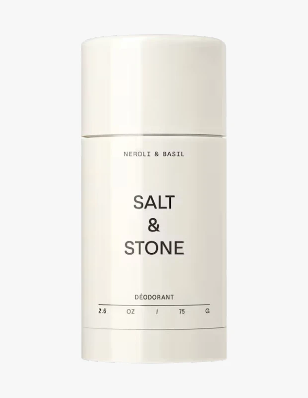 Bu görselde, Salt & Stone markasının Neroli & Basil aromalı, silindirik formda, sade ve minimalist krem rengi ambalajıyla öne çıkan, üzerinde siyah harflerle marka ve içerik bilgileri yazan bir deodorant çubuğu sergileniyor.