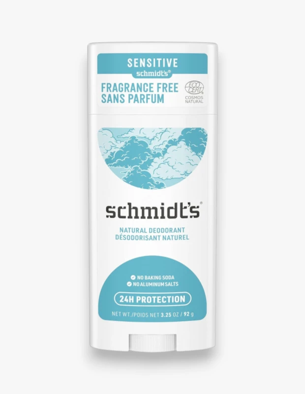Schmidt's markasına ait, hassas ciltler için formüle edilmiş, beyaz renkli bir doğal deodorant çubuğu; üzerinde SENSITIVE, FRAGRANCE FREE ve NATURAL DEODORANT yazılarıyla kokusuz ve doğal olduğu vurgulanan ürünün ambalajında açık mavi bulut desenleri, EcoCert logosu ve baking soda ile alüminyum tuzu içermediği, 24 saat koruma sağladığı bilgileri dikkat çekiyor.