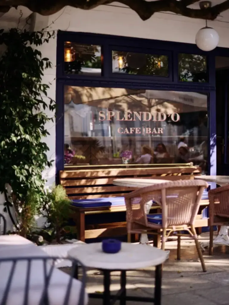 Büyükada’daki Splendid’O Cafe Bar’ın önünde, ahşap oturma alanı ve hasır sandalyelerle düzenlenmiş zarif bir açık hava oturma bölümü
