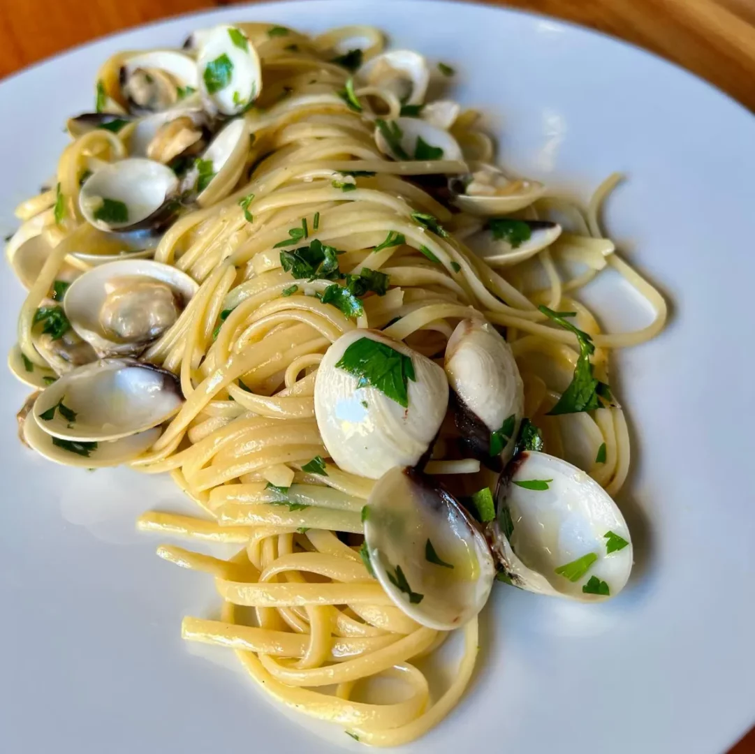 Rodos'taki Tamam Restaurant'ın nefis deniz mahsulleri spesiyalitelerinden biri olan, taze maydanoz ve zengin sosuyla hazırlanmış midyeli linguine makarnası beyaz bir tabakta iştah açıcı bir şekilde servis edilmiş.
