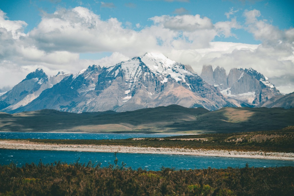 Torres del Paine Ulusal Parkı’nda karla kaplı And Dağları ve masmavi göl manzarası, Patagonya – Şili