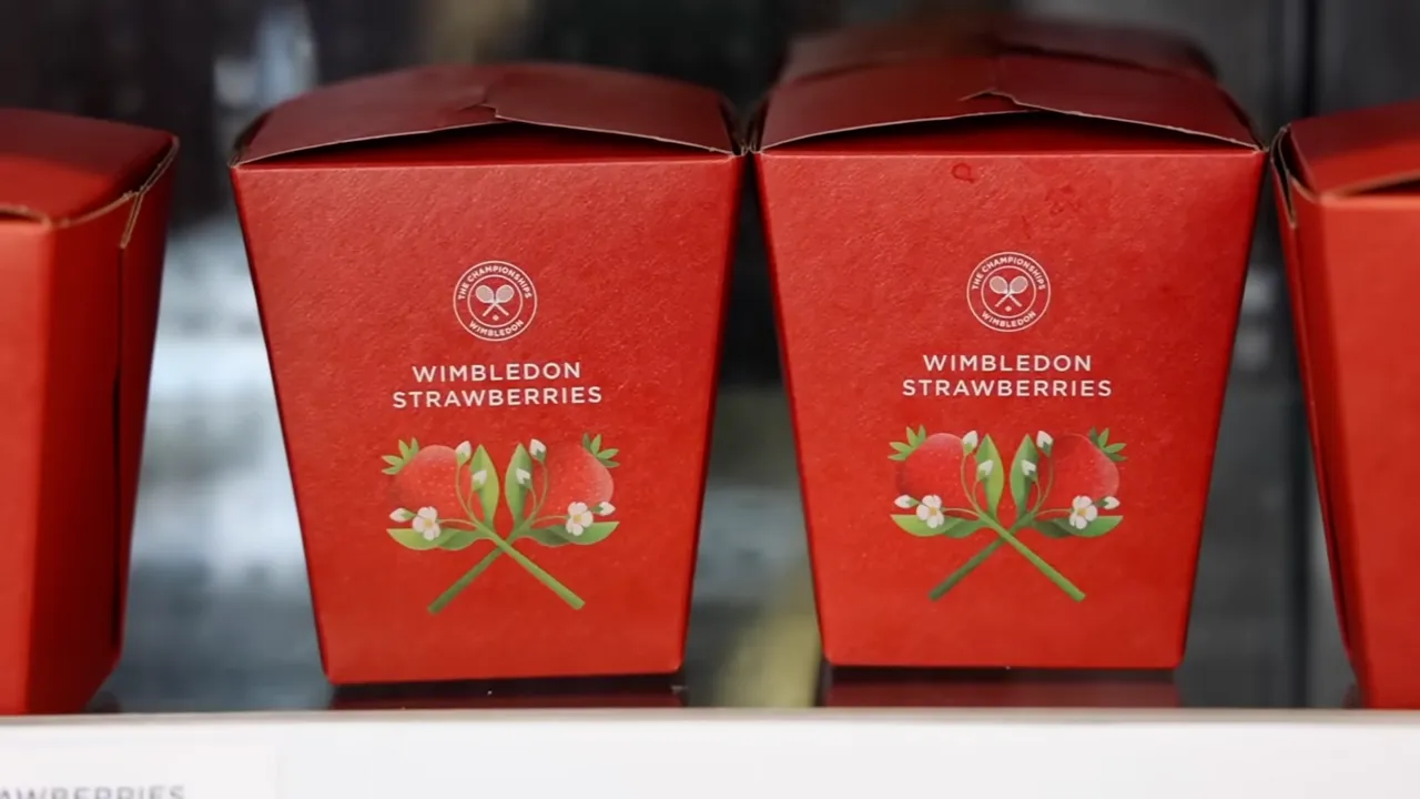 Kırmızı renkli, üzerinde The Championships Wimbledon logosu ve çilek illüstrasyonu bulunan, Wimbledon Çilekleri yazan kapalı karton kutular rafta yan yana sıralanmış, etkinliğin ikonik lezzeti çilek ve kremayı çağrıştırıyor.