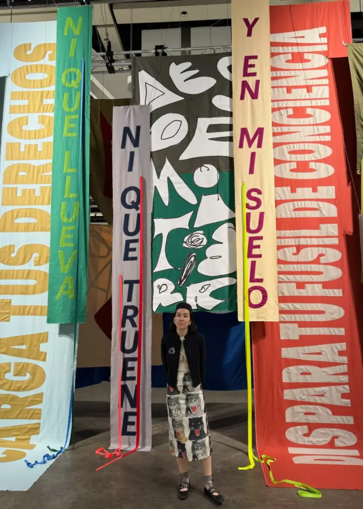 Metin, desen ve renk oyunlarıyla kurgulanan manifesto niteliğindeki kumaş enstalasyonu, Art Basel Hong Kong 2025’te politik sanatın güçlü örneklerinden biri olarak öne çıktı.