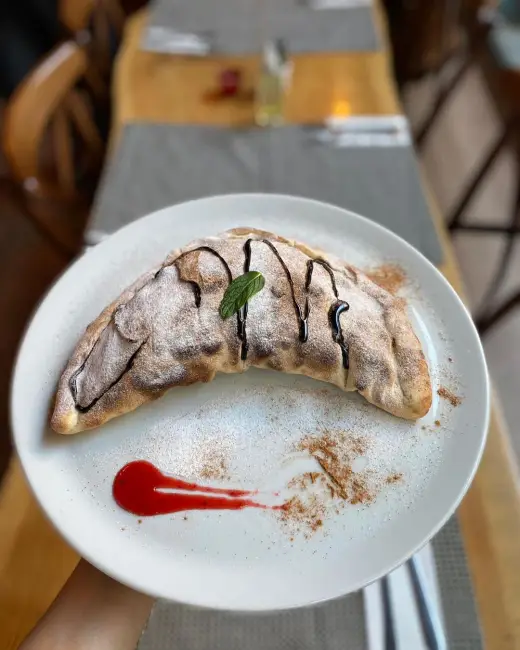 Burrata peyniri, çilek ve kırmızı sosla hazırlanan tabak.