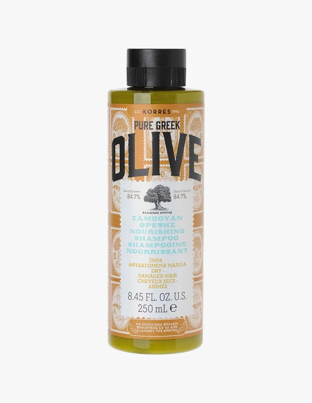 Korres Pure Greek Olive Besleyici Şampuan'ın zeytin yeşili, siyah kapaklı 250 ml şişesi, kahverengi-altın rengi etiketinde belirgin OLIVE yazısı, zeytin ağacı çizimi ve kuru-yıpranmış saçlar için besleyici özelliklerini açıklayan metinler sunmaktadır.