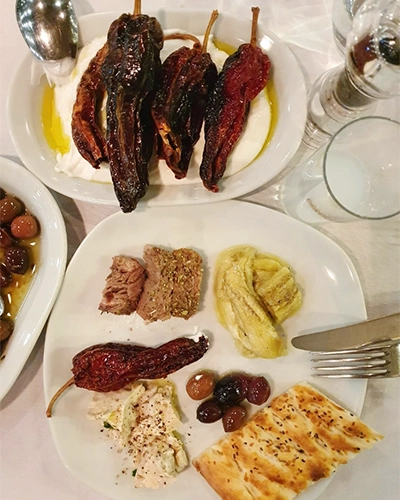 Meze tabağı: köz biber, ezme, humus ve zeytin çeşitleri.