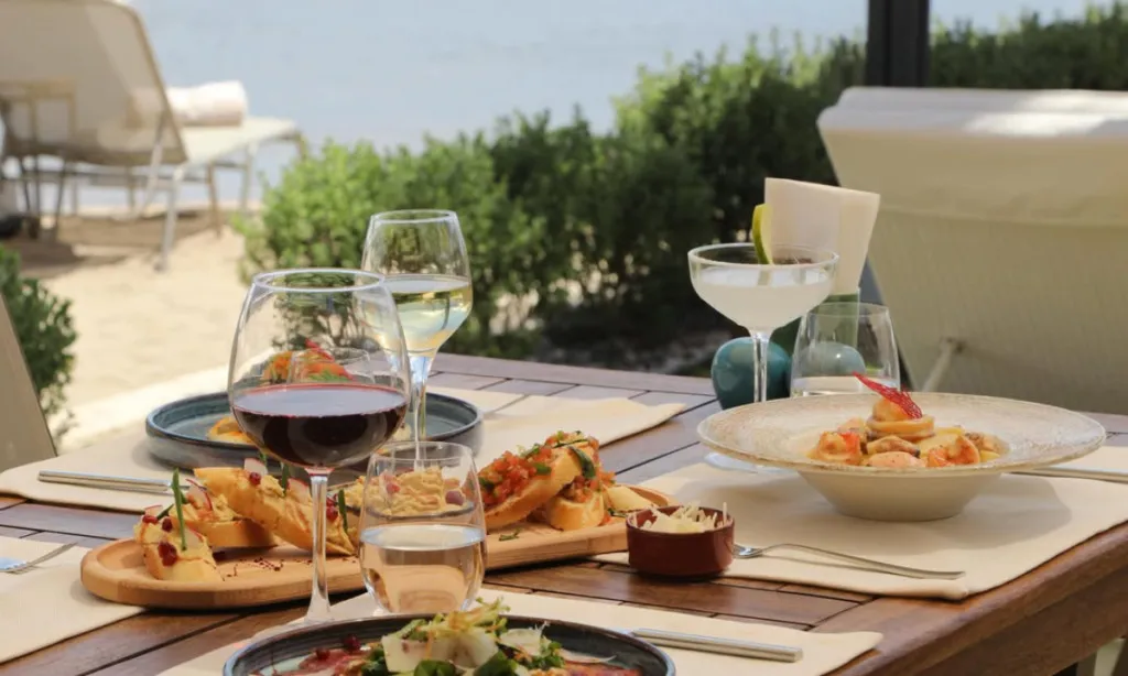 Cio Beach Club & Restaurant Ortakent Yahşi sahilinde denize sıfır masada yemekler, içecekler ve sakin Bodrum denizi