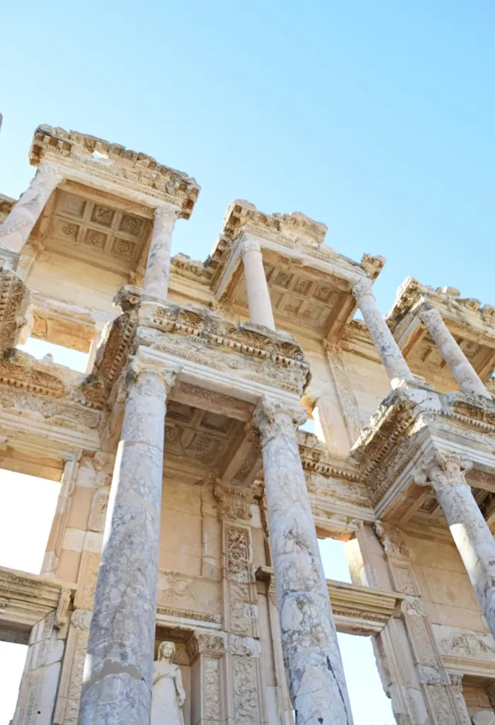 Efes Antik Kenti'nin UNESCO Dünya Mirası statüsündeki en ikonik yapılarından biri olan Celsus Kütüphanesi'nin, detaylı kabartmalar, heykeller ve Korint başlıklı mermer sütunlarla bezeli, masmavi gökyüzü altında yükselen büyüleyici ve çok katmanlı cephesi.