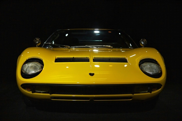 Sarı Lamborghini Miura, otomotiv tarihinde süper otomobil kavramını başlatan ikonik model. Önden görünümüyle agresif tasarımı ve karakteristik far detayları dikkat çekiyor.