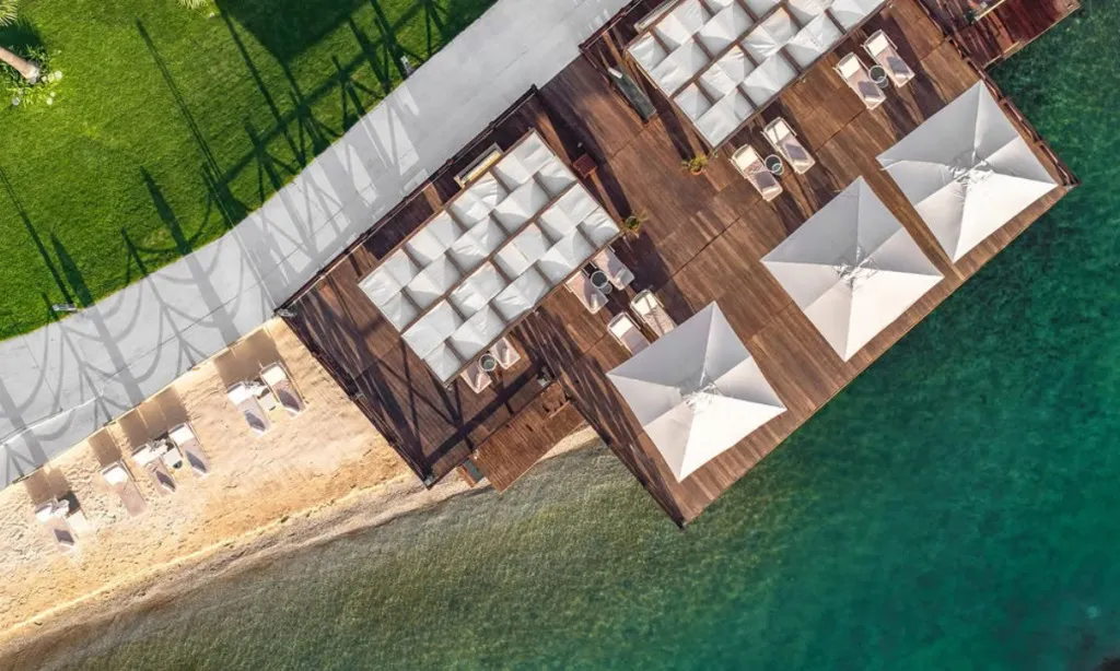 Mivara Luxury Resort & Spa Gündoğan’da kum plaj, ahşap iskele, cabanalar ve turkuaz deniz manzarası