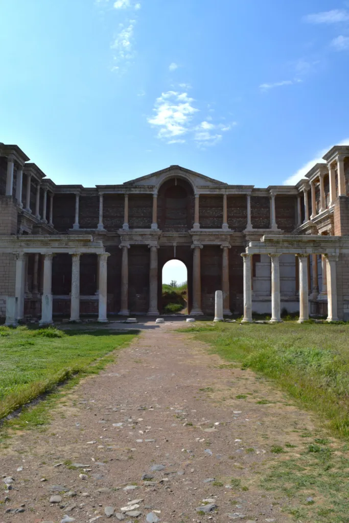 Manisa'daki Sardes Antik Kenti'nin geniş alanında, sütunlarla çevrili, anıtsal bir kemerli giriş kapısı ve çok katlı duvarlarıyla uzanan, 2025'te UNESCO Dünya Mirası Listesi'ne dahil edilen etkileyici gymnasium ve hamam kompleksi.