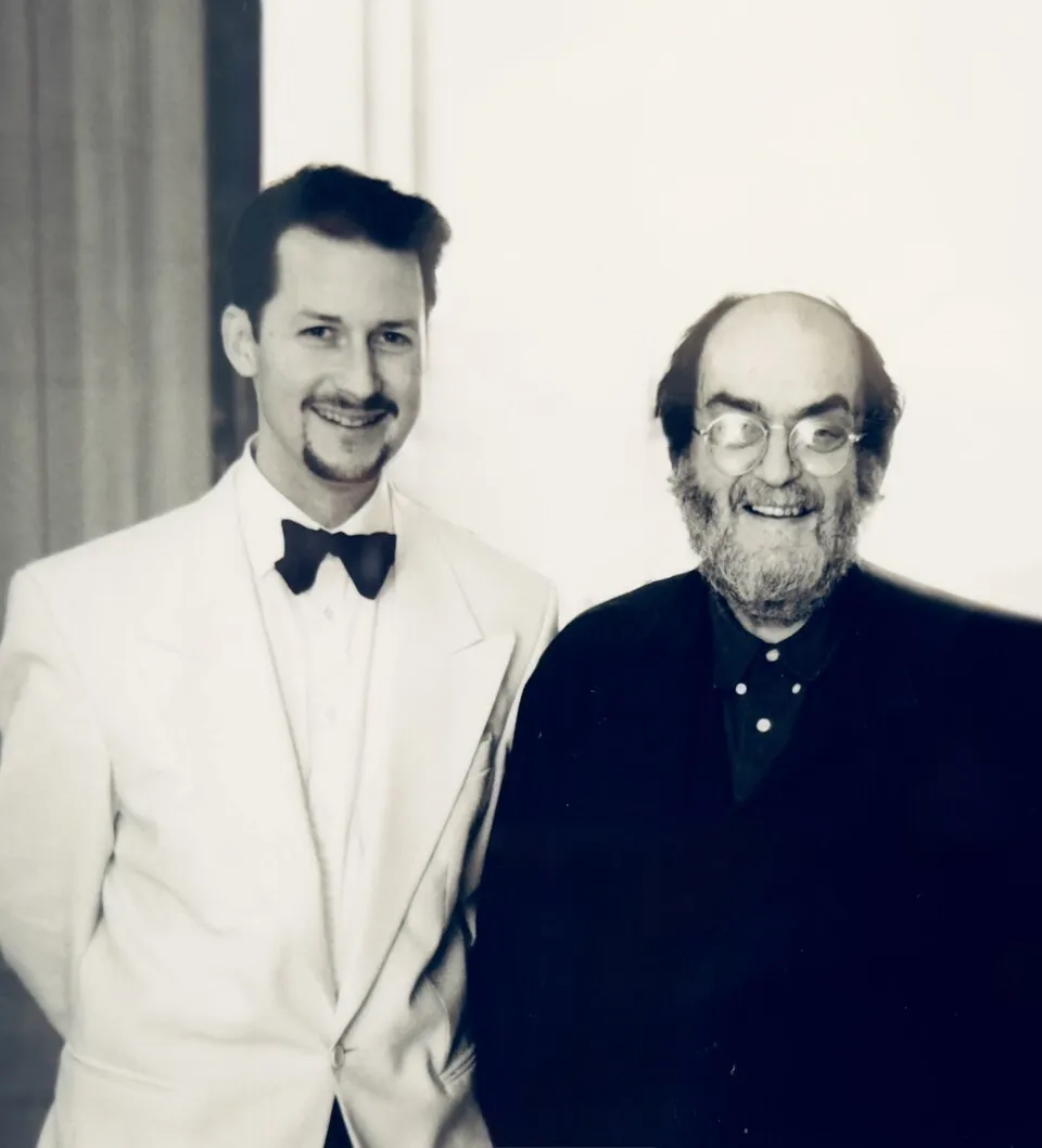 Genç yönetmen Todd Field, beyaz smokin ve papyonuyla gülümseyerek efsanevi yönetmen Stanley Kubrick'in yanında dururken çekilen bu siyah beyaz fotoğrafta, Kubrick'in koyu renk hırkası ve karakteristik gözlükleri dikkat çekiyor.