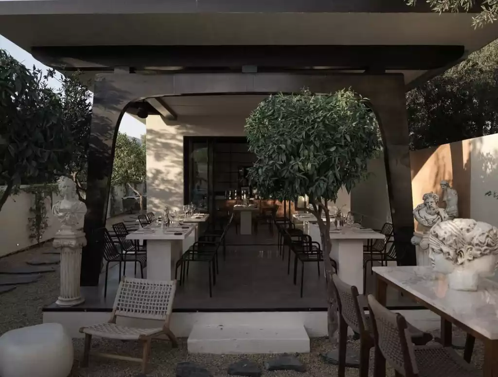 Bodrum'un çağdaş ve zarif atmosferini yansıtan bu açık hava mekanında, klasik büstlerin süslediği çakıllı bahçe zemininde, ortada küçük bir ağaçla birlikte modern şık sandalyelerle çevrili uzun beyaz masalar, üstü kapalı bir dining alanında misafirlerini bekliyor.