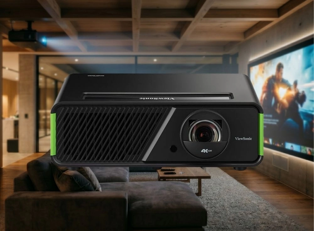 Yeni nesil oyuncular için tasarlanmış, yanlarındaki parlak yeşil detaylarla Xbox lisanslı olduğunu belli eden siyah ViewSonic 4K HDR oyuncu projeksiyonu, modern bir oturma odasında büyük ekrana canlı bir oyun sahnesi yansıtıyor.