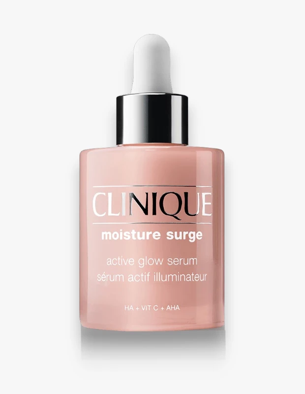 Beyaz bir arka plan üzerinde, Clinique Moisture Surge Active Glow Serum adlı pembe renkli damlalıklı şişe, gümüş detaylı kapağı ve üzerinde nem ile ışıltı veren bir serum olduğunu belirten yazılarıyla belirgin bir şekilde duruyor.