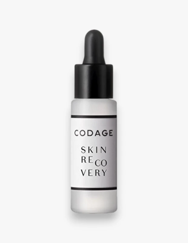 Beyaz bir arka plan üzerinde, CODAGE markasına ait, cilt yenileme özelliğiyle öne çıkan, üzerinde belirgin bir şekilde SKIN RECOVERY ibaresi bulunan, siyah damlalıklı ve buzlu cam şişede sunulan bir serum ürünü net bir şekilde görülmektedir.