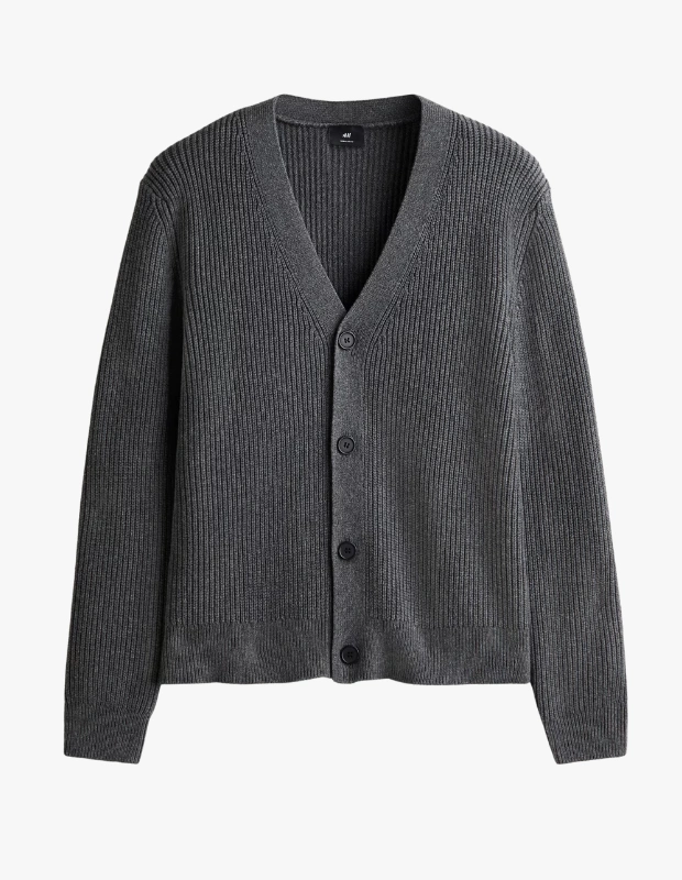 Ürün Cinsiyeti
Erkek

Ürün Tipi
Hırka

Ürün Sezonsallığı
Sonbahar / Kış

Ürün Çeşidi
V Yaka Düğmeli Pamuk Karışımlı Hırka

Ürün Özellikleri
H&M koleksiyonuna ait bu pamuk karışımlı hırka, yumuşak lastik örgü dokusuyla günlük kullanımda konforu ve zamansız şıklığı bir araya getirir. Derin V yaka ve önü düğmeli tasarımı klasik bir silüet sunarken, düşük omuz kesimi parçaya modern ve rahat bir hava katar. İnce lastik örgülü kenarlar, manşetler ve etek ucu formu dengelerken temiz bir bitiş sağlar. Normal kesimi sayesinde katmanlı kombinlerde kolayca kullanılabilir. Pamuk ve poliamid karışımlı kumaşı yumuşak bir his sunarken, dayanıklılığı ve form korumasıyla uzun süreli kullanım vadeder.

Öne Çıkan Detaylar
• Pamuk karışımlı yumuşak lastik örgü kumaş
• Derin V yaka tasarım
• Düğmeli ön kapama
• Düşük omuz kesimi
• İnce lastik örgülü manşet ve etek ucu
• Normal kesim, rahat kullanım
• Düz renk, zamansız stil

Kimler Kullanıyor?
Rahat ama özenli bir stil benimseyen, klasik hırka formunu modern detaylarla giymeyi seven erkekler için ideal bir parça. Günlük şehir hayatından ofis sonrası kombinlere kadar farklı ortamlarda zahmetsiz bir şıklık sunar.

Pamuk karışımlı V yaka hırka, yumuşak dokusu ve sade tasarımıyla sonbahar ve kış kombinleri için konforlu, zamansız bir tamamlayıcıdır.
