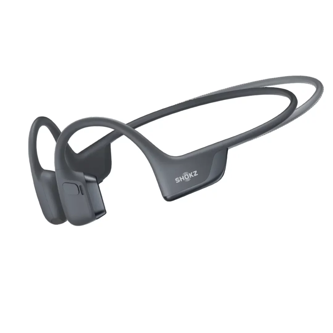Beyaz bir arka plan üzerinde, şık ve ergonomik tasarımlı koyu gri renkte Shokz OpenRun Pro 2 kemik iletimli kulaklık, yan tarafındaki Shokz logosuyla birlikte hafif açılı bir şekilde net olarak görülmektedir.