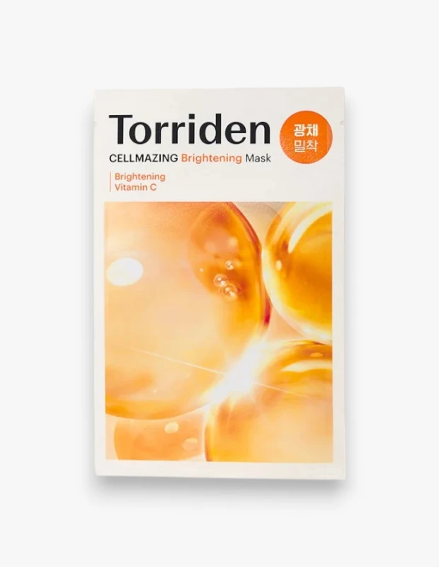 Torriden CELLMAZING Brightening Maske'nin beyaz, dikdörtgen ambalajı, parlak turuncu ve altın tonlarındaki ışık saçan damlacıklar veya kapsüllerle süslenmiş olup, üzerinde Brightening Mask ve Vitamin C yazılarıyla ürünün aydınlatıcı etkisini ve C Vitamini içeriğini ön plana çıkarıyor.