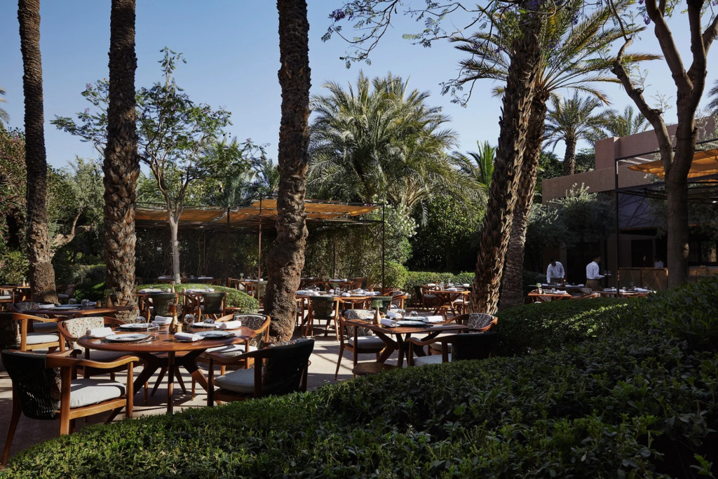 Royal Mansour'un yemyeşil bahçeleri içinde, uzun palmiye ağaçları gölgesinde özenle hazırlanmış yuvarlak ahşap masaların yer aldığı, Marakeş'in en iyi restoranlarından biri olan Le Jardin Restaurant'ın açık hava yemek alanı, huzurlu ve zarif bir deneyim sunuyor.