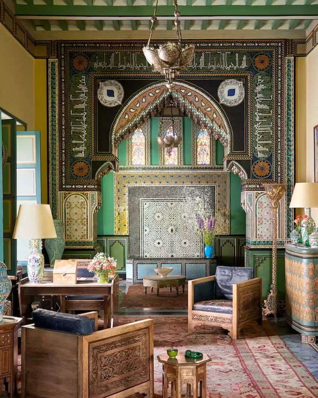 Marakeş'in renklerle uyanan rüya gibi atmosferini yansıtan, Yves Saint Laurent'in ilham aldığı Villa Oasis'in rafine iç mekan kurgusu, yeşil ve altın tonlarında zengin geometrik desenler, oymalı ahşap mobilyalar ve vitray pencerelerle süslü gösterişli bir salon.