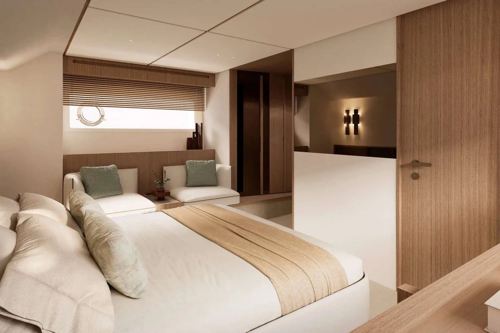 Modern bir Azimut Fly tekne yat kabininde, beyaz nevresimli rahat bir yatak, porthole pencerenin altında yeşil yastıklı iki koltuk ve ahşap detaylarla tasarlanmış şık bir iç mekan görülüyor.