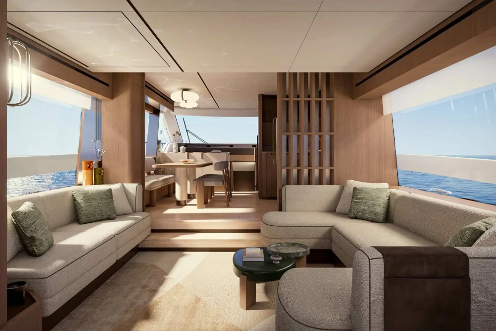 Azimut Fly yatın modern iç mekanında, denizin maviliğiyle bütünleşen geniş pencereler önünde krem rengi koltuklar, yeşil yastıklar ve minimalist ahşap detaylarla tasarlanmış bir oturma alanı ile yemek bölümü görülüyor.