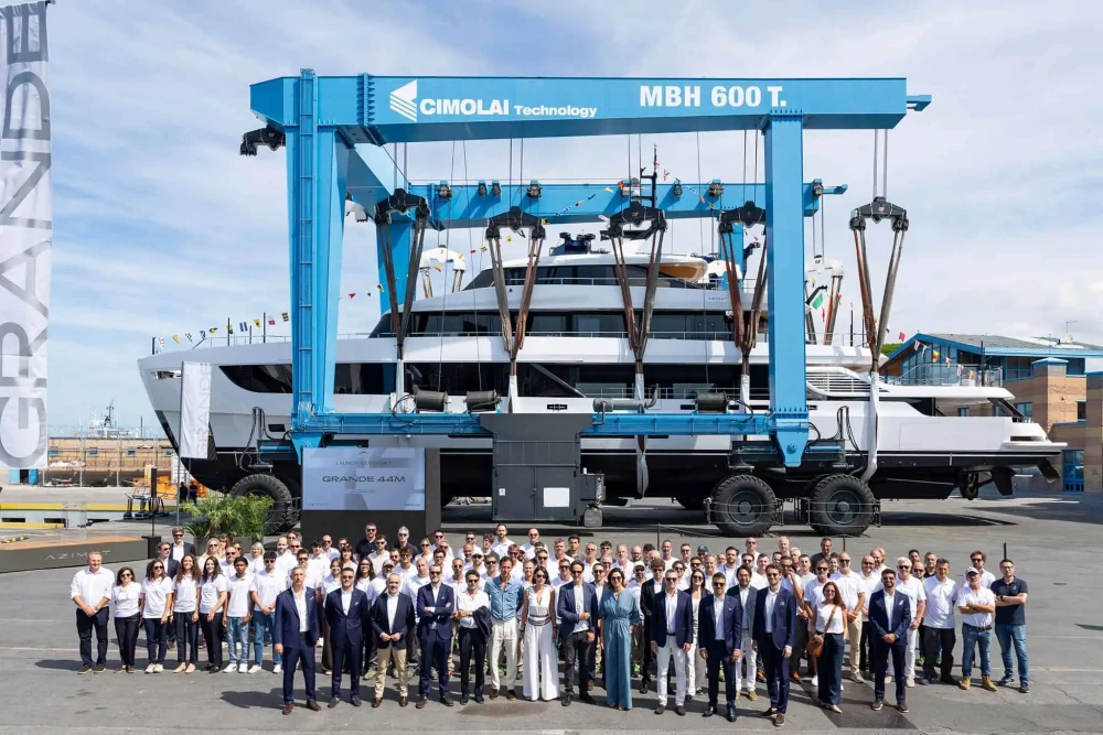 Azimut Grande 44M'in lansman töreninde, devasa bir Cimolai lift tarafından karadan denize indirilen görkemli en büyük Azimut yatının önünde, Azimut ekibinden kalabalık bir grup fotoğraf için poz veriyor.