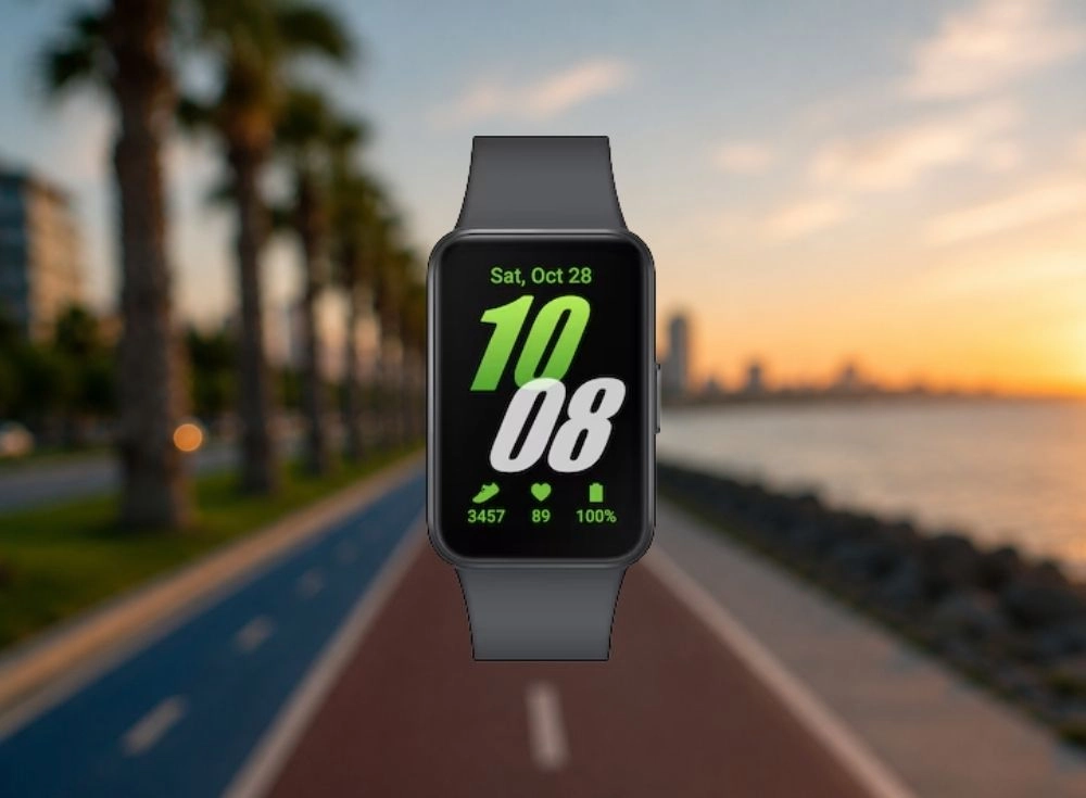 Siyah renkli Samsung Galaxy Fit3 akıllı bileklik, 1.6 inç AMOLED ekranında 10:08 saatini, 28 Ekim tarihini, 3457 adım, 89 nabız ve 0 pil seviyesini gösterirken, arka planda gün batımının kızıla boyadığı bir deniz kenarı koşu parkuru ve palmiye ağaçları seçilmektedir.