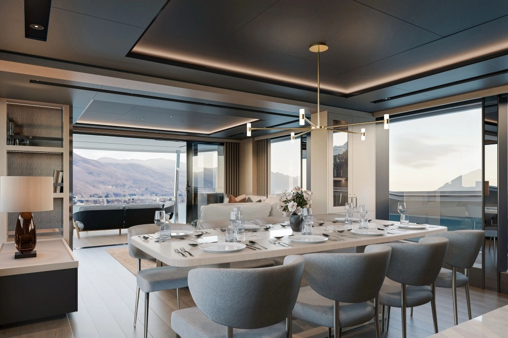 Bu süper yatın modern iç mekanı, şık bir yemek masası, tasarım avize, konforlu bir oturma alanı ve dağ ile denizin panoramik manzarasına açılan geniş sürgülü cam kapılarla lüks bir yaşam alanı sunuyor.
