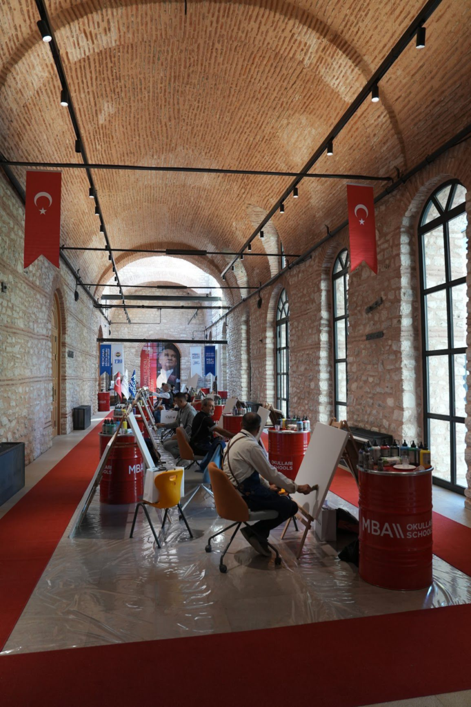 Türk Bayrakları altında tuval çalışması yapan insanlar
