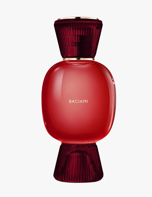 Parlak kırmızı tonlarında, orta kısmındaki BACIAMI yazısıyla öne çıkan, kıvrımlı geniş gövdeli Bvlgari Allegra Baciami parfüm şişesi, üst ve alt kısımlarında yer alan koyu bordo renkli, yivli cam detaylar ve zarif altın vurgularla lüks bir görünüm sergiliyor.