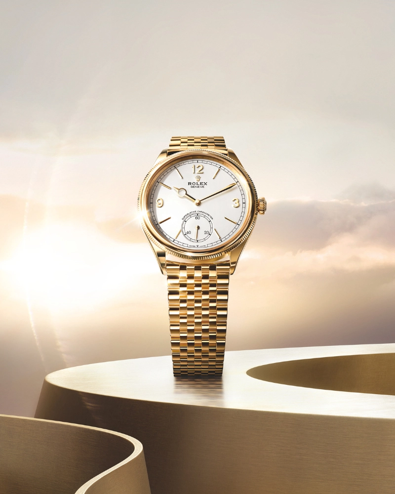 Altın bilezikli Rolex klasik model saat, zarif kadran tasarımıyla güneş ışığı fonunda sergileniyor; lüks saatçilik ve zamansız stil.