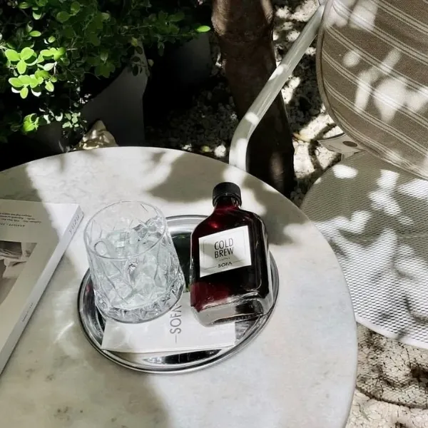 Moda Sofa’da masada soğuk kahve şişesi ve minimalist kahve sunumu
