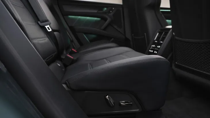 Porsche Cayenne Electric’in geniş arka koltukları, lüks döşemeleri ve arka iklimlendirme paneliyle sunulan konfor odaklı iç mekân detayları.