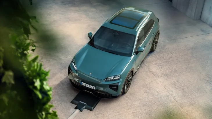 Yeni Porsche Cayenne Electric’in kablosuz şarj ünitesinin üzerinde pozisyonlanan üstten görünümü; inductive charging teknolojisi ve modern EV platformu.